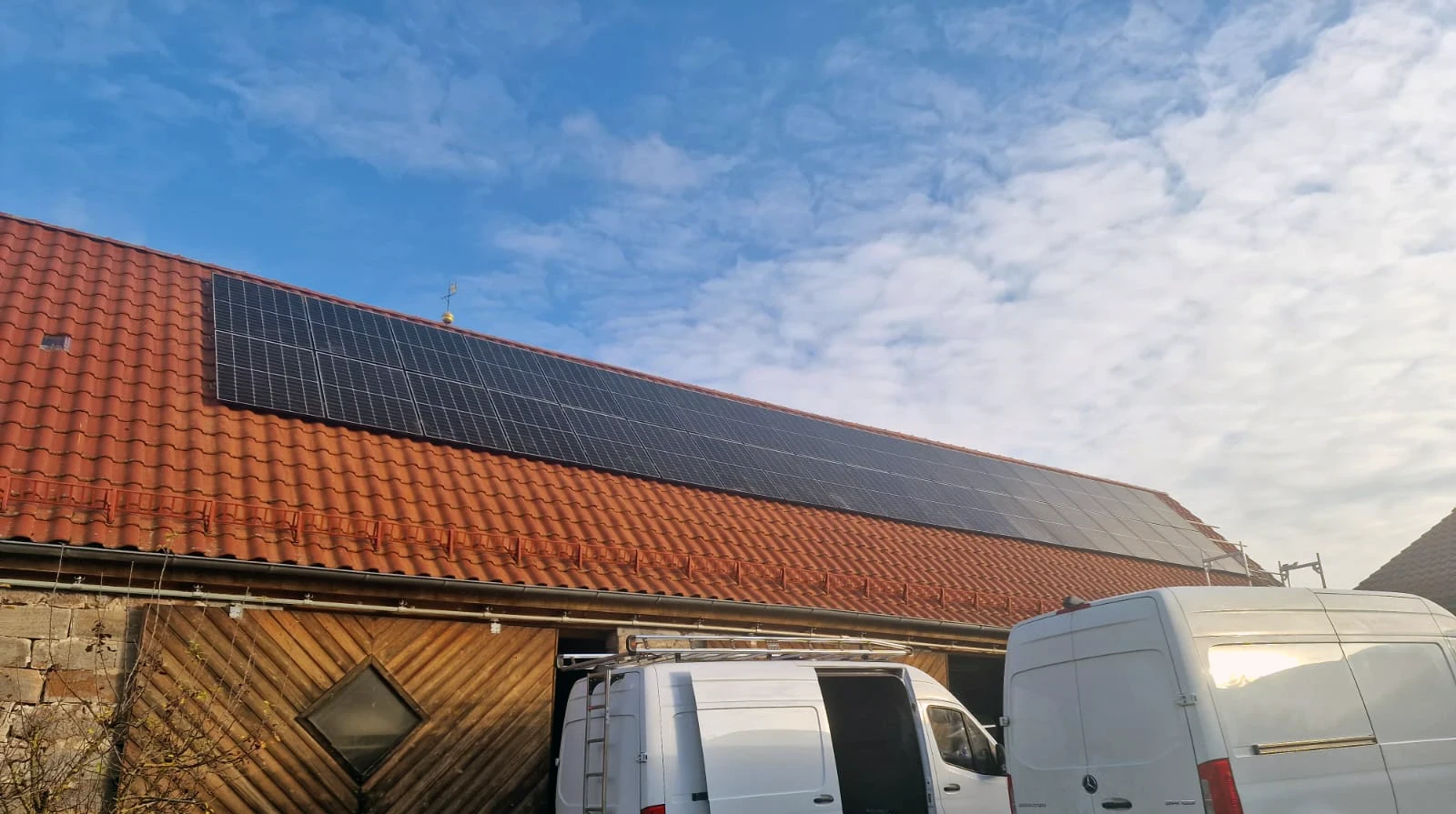 Photovoltaikanlage auf dem Dach einer großen Scheune mit roter Ziegelfläche, installiert von Sunna Energie und Elektro - nachhaltige Stromerzeugung im ländlichen Raum